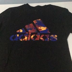 Small unisex t-shirt in black, with a color splashes spelling adidas.